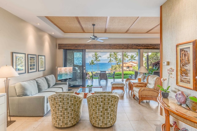 living room with ceiling fan, light tile patterned floors, wooden ceiling, and a water view