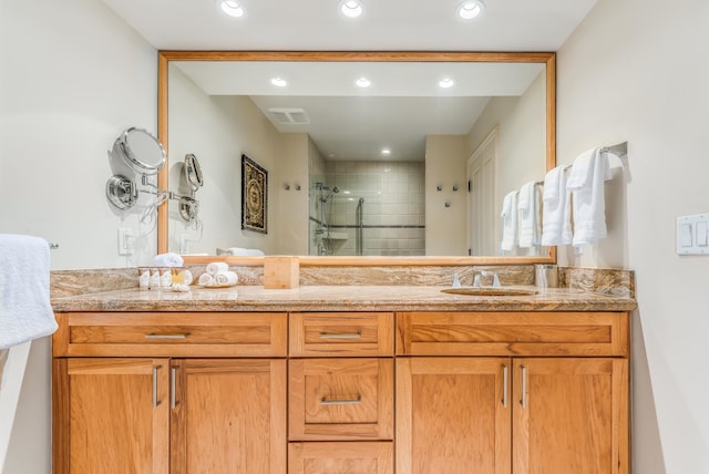 bathroom with double vanity and a shower with door