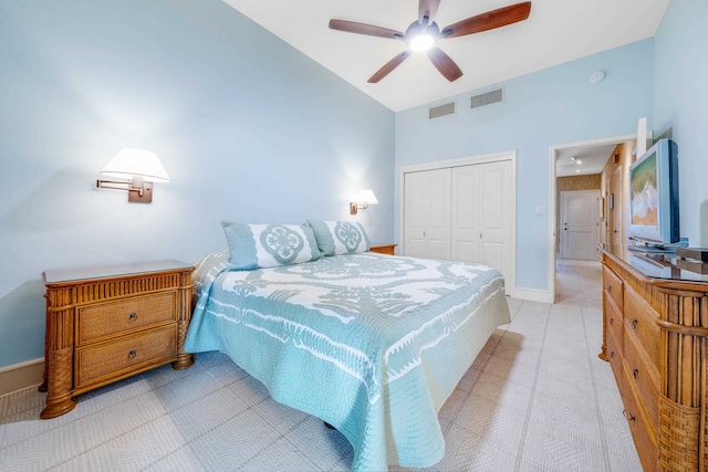 tiled bedroom with ceiling fan, a closet, and vaulted ceiling