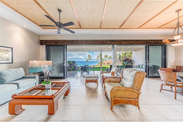 tiled living room featuring ceiling fan and a water view