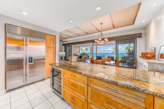 kitchen with a wealth of natural light, beverage cooler, refrigerator, and a water view