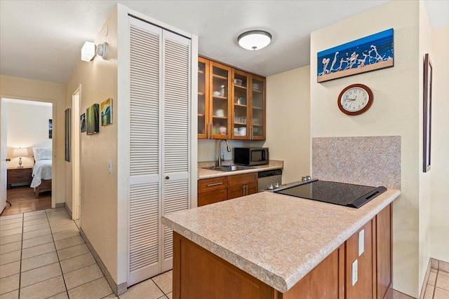 kitchen featuring sink, kitchen peninsula, stainless steel appliances, and light tile patterned floors