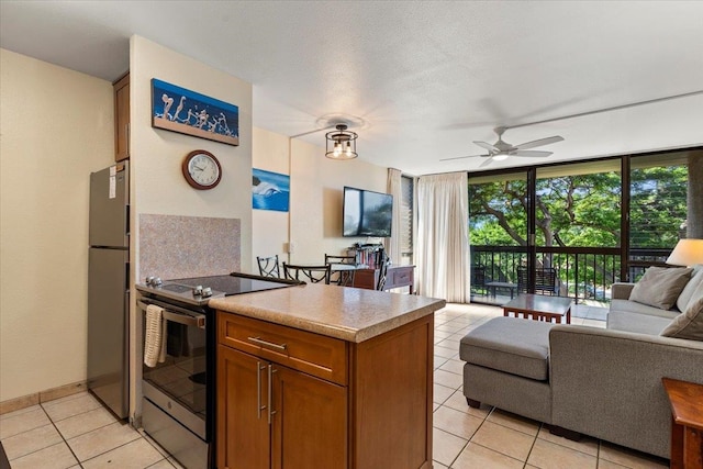 kitchen featuring appliances with stainless steel finishes, ceiling fan, a wall of windows, decorative backsplash, and light tile patterned floors