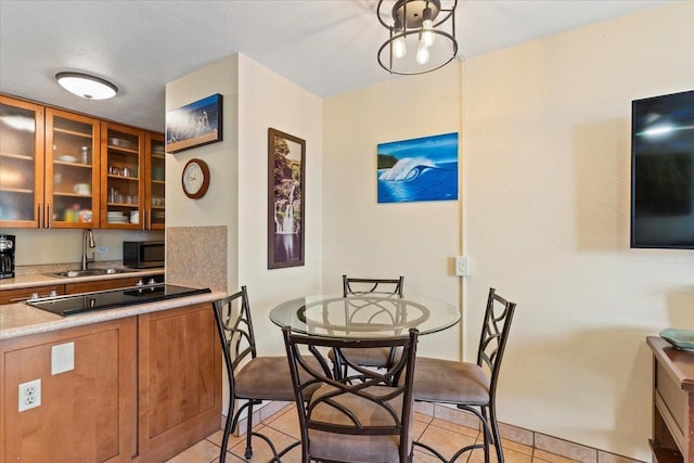 dining space featuring light tile patterned floors, a textured ceiling, and sink