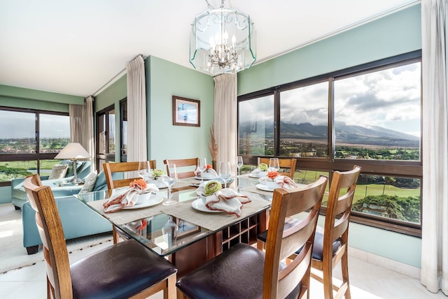 tiled dining room featuring a mountain view, a notable chandelier, and a wealth of natural light