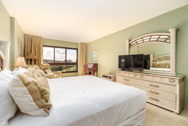 bedroom with decorative columns and light colored carpet