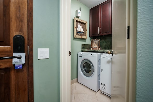 laundry area featuring cabinets, independent washer and dryer, and light tile floors