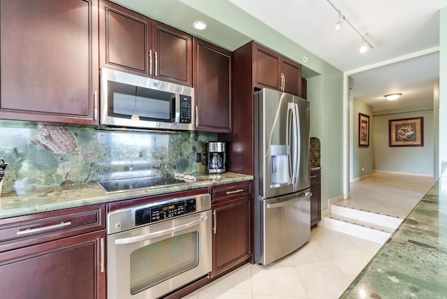 kitchen featuring rail lighting, tasteful backsplash, light tile flooring, and appliances with stainless steel finishes