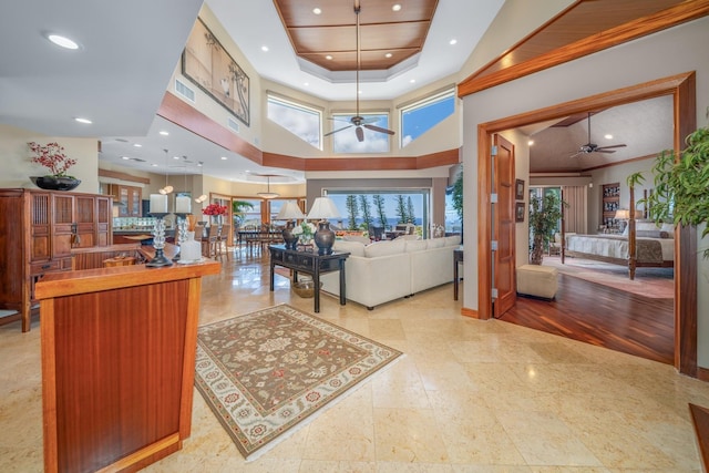 interior space featuring a towering ceiling, ceiling fan, and ornamental molding