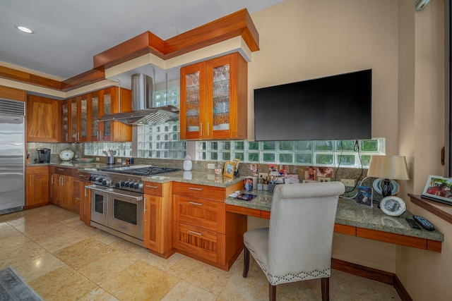 kitchen featuring tasteful backsplash, light stone counters, extractor fan, and high end appliances