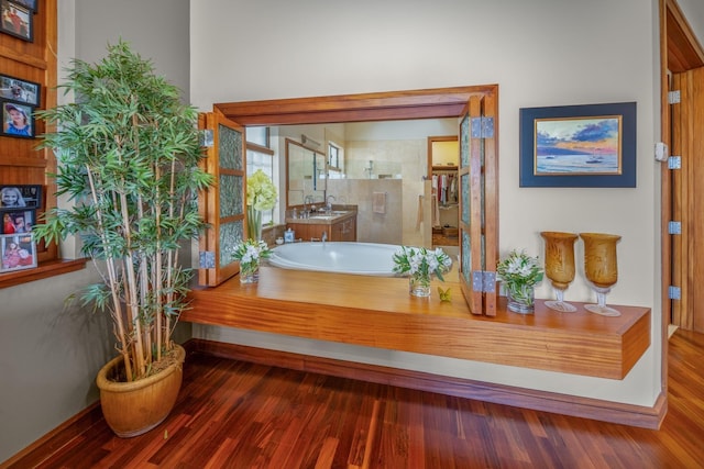 bathroom with hardwood / wood-style flooring, independent shower and bath, and sink