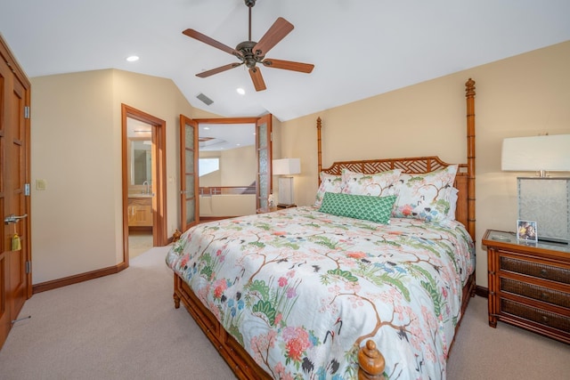 bedroom with ceiling fan, lofted ceiling, ensuite bathroom, and light carpet