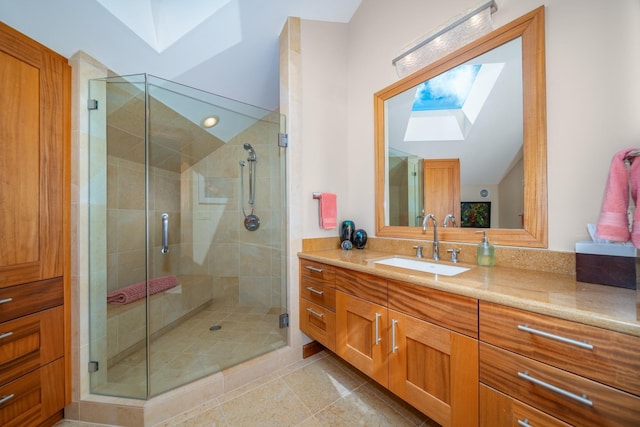 bathroom with lofted ceiling with skylight, tile patterned flooring, vanity, and a shower with shower door