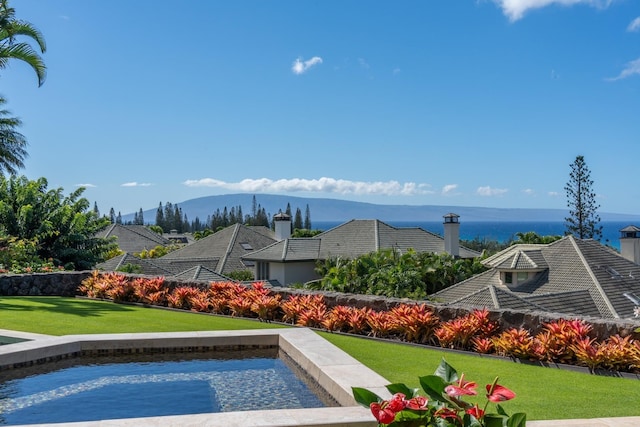 view of swimming pool with a mountain view and a yard