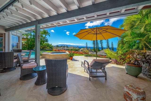 view of patio featuring a mountain view and a swimming pool with hot tub