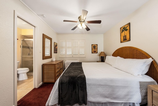 bedroom with dark tile patterned flooring, ensuite bath, and ceiling fan