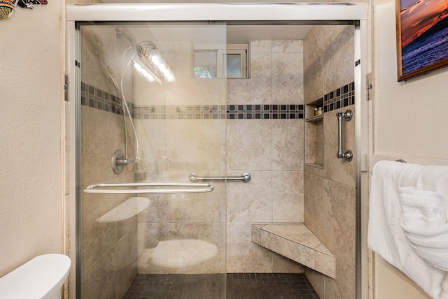 bathroom featuring toilet and an enclosed shower