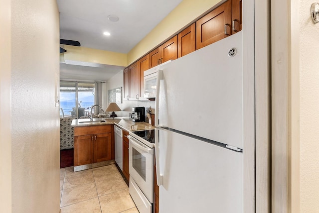 kitchen with white appliances, light tile patterned floors, and sink