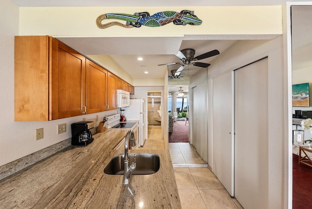 kitchen featuring ceiling fan, sink, light tile patterned floors, and white appliances