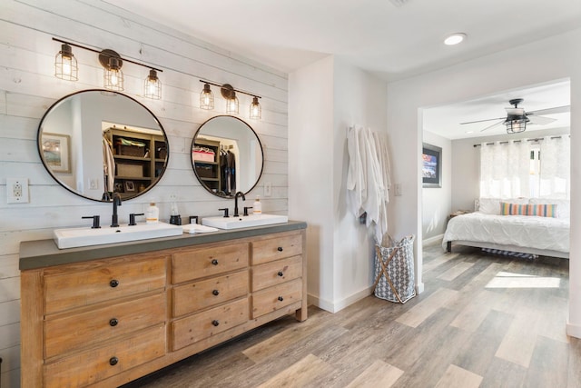 bathroom with ceiling fan, vanity, wooden walls, and hardwood / wood-style flooring