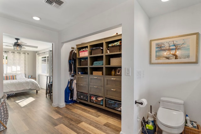 bathroom featuring ceiling fan, hardwood / wood-style floors, and toilet