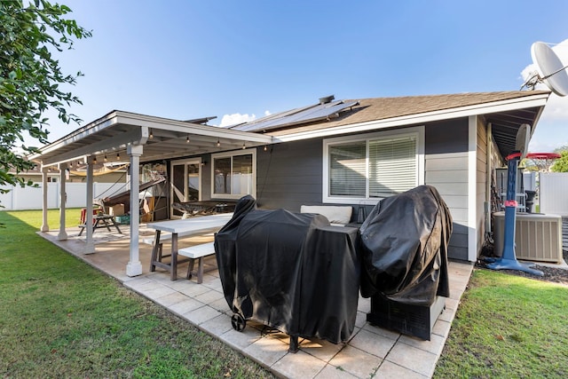 back of house featuring a yard, solar panels, a pergola, a patio area, and central air condition unit