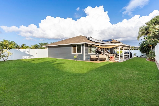 back of house featuring a lawn and a patio area