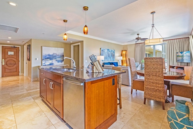 kitchen featuring a center island with sink, sink, decorative light fixtures, light tile patterned floors, and stainless steel dishwasher