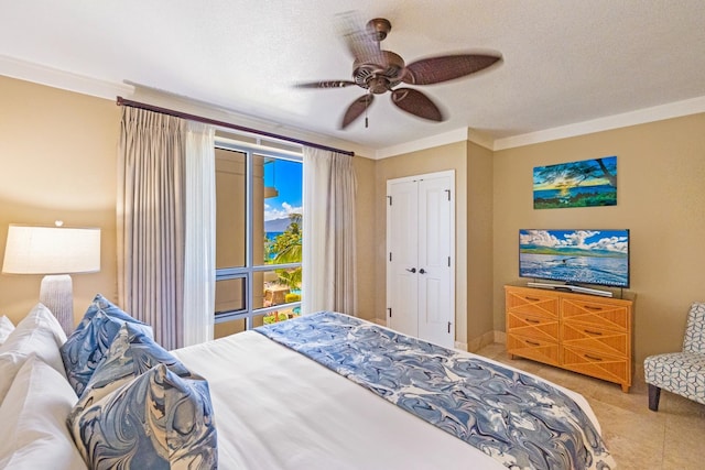 bedroom with a textured ceiling, crown molding, light tile patterned floors, and ceiling fan