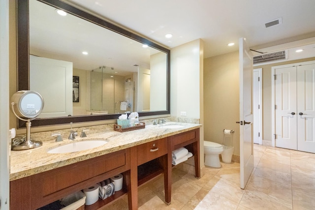 bathroom featuring tile patterned floors, toilet, and double sink vanity