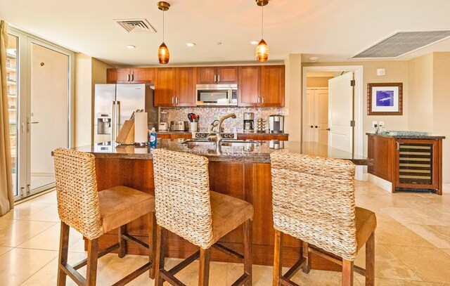 130 Kai Malina Pkwy Unit Sr409, Lahaina, HI 96761 - kitchen featuring stainless steel appliances, brown cabinetry, backsplash, a sink, and light tile patterned floors