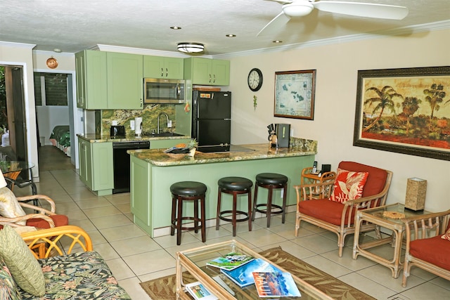 kitchen featuring green cabinets, black appliances, a breakfast bar area, kitchen peninsula, and ceiling fan