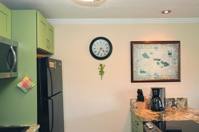 interior space with ornamental molding, light stone counters, green cabinets, and black fridge