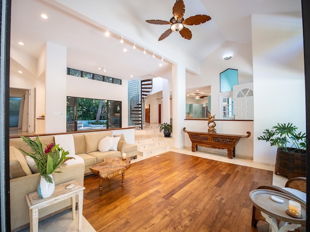 living room featuring ceiling fan, high vaulted ceiling, and wood-type flooring