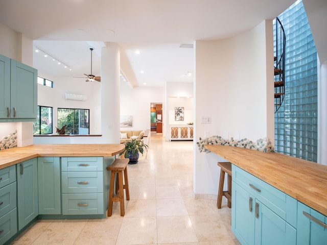 kitchen featuring light tile patterned floors, rail lighting, butcher block countertops, and ceiling fan