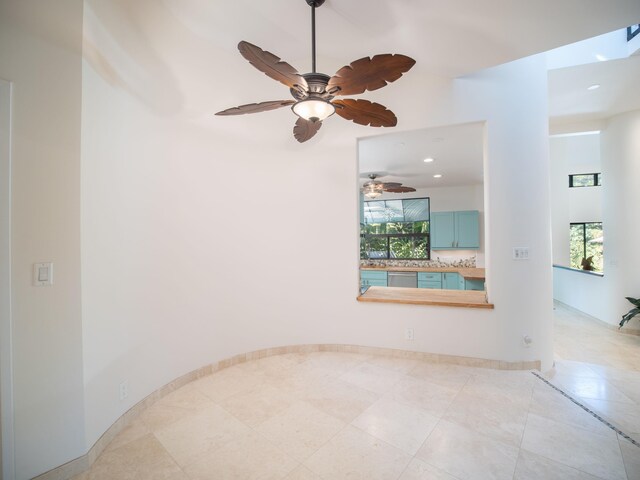 tiled spare room featuring ceiling fan