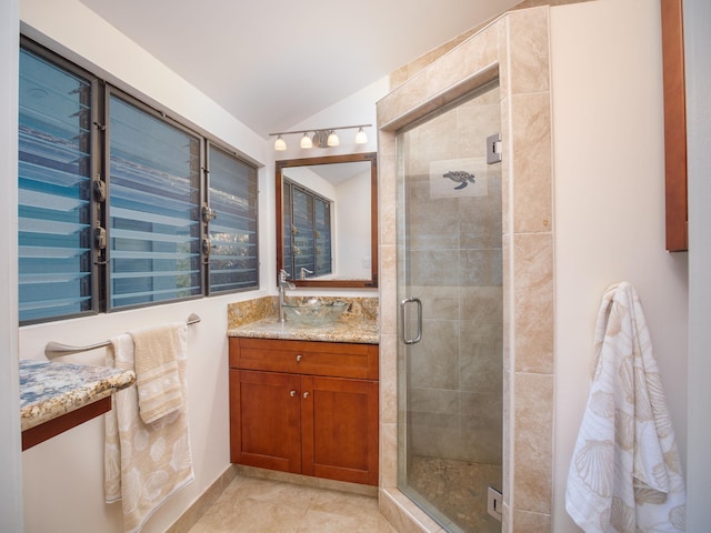 bathroom with tile patterned floors, vanity, a shower with door, and lofted ceiling