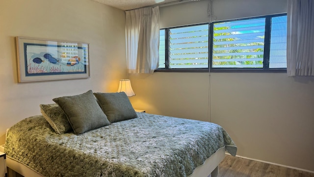 bedroom with multiple windows and wood-type flooring