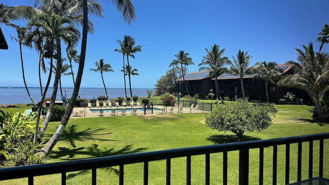 view of home's community featuring a yard, a swimming pool, and a water view