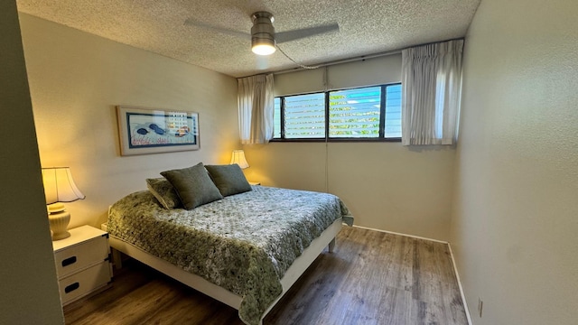 bedroom featuring ceiling fan, a textured ceiling, and dark hardwood / wood-style flooring