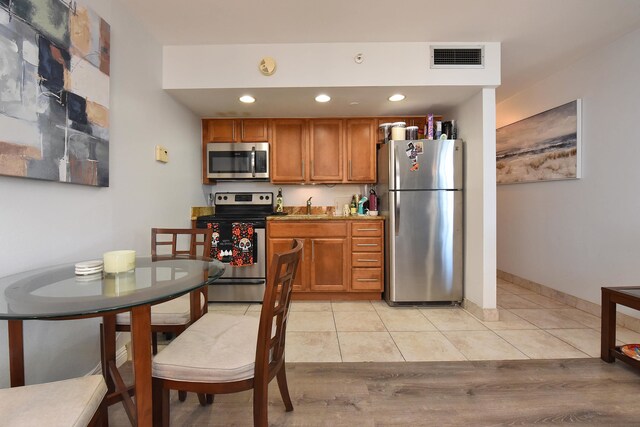 kitchen featuring stainless steel appliances, sink, and light hardwood / wood-style flooring