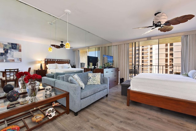 bedroom with access to exterior, ceiling fan, and wood-type flooring