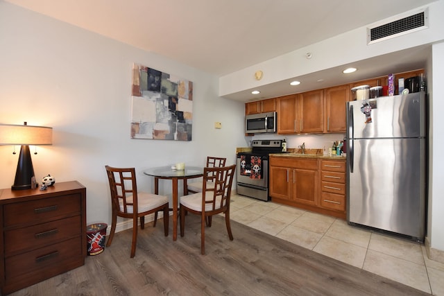 kitchen with light tile patterned flooring, appliances with stainless steel finishes, and sink