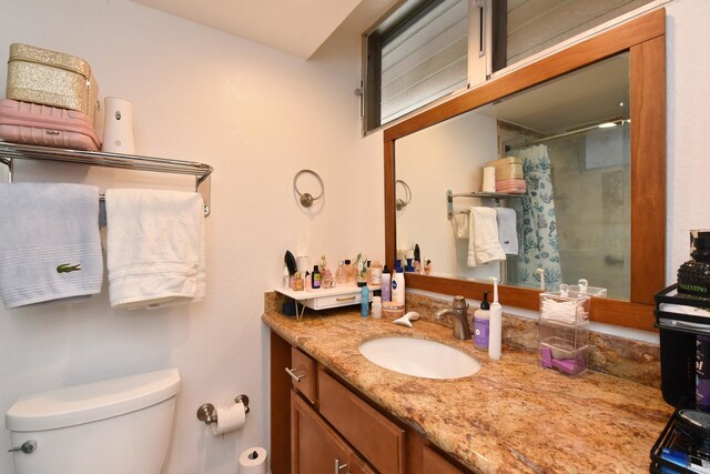 bathroom featuring a shower with shower curtain, vanity, and toilet