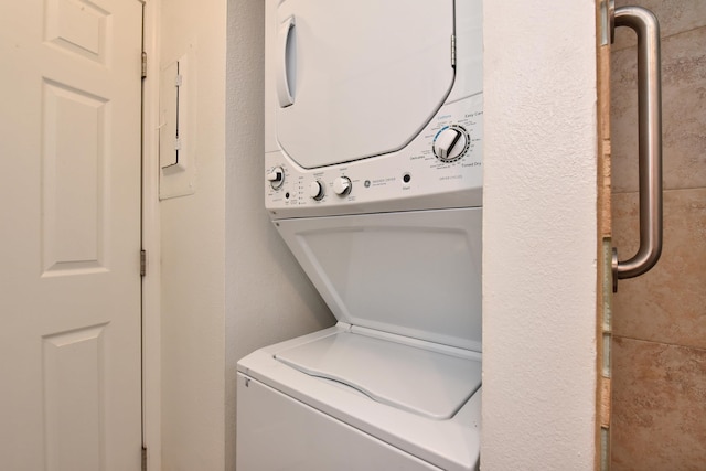 washroom featuring stacked washer / drying machine