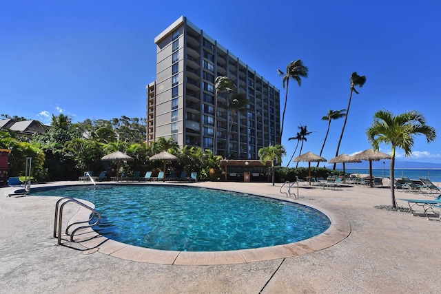 view of pool featuring a water view and a patio area