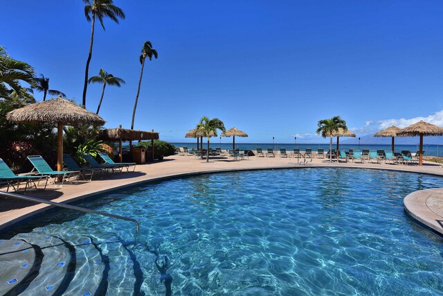 view of swimming pool featuring a water view and a patio