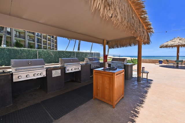 view of patio with a water view, area for grilling, and exterior kitchen