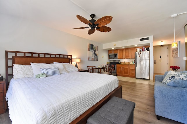 bedroom featuring light wood-type flooring, ceiling fan, and stainless steel refrigerator