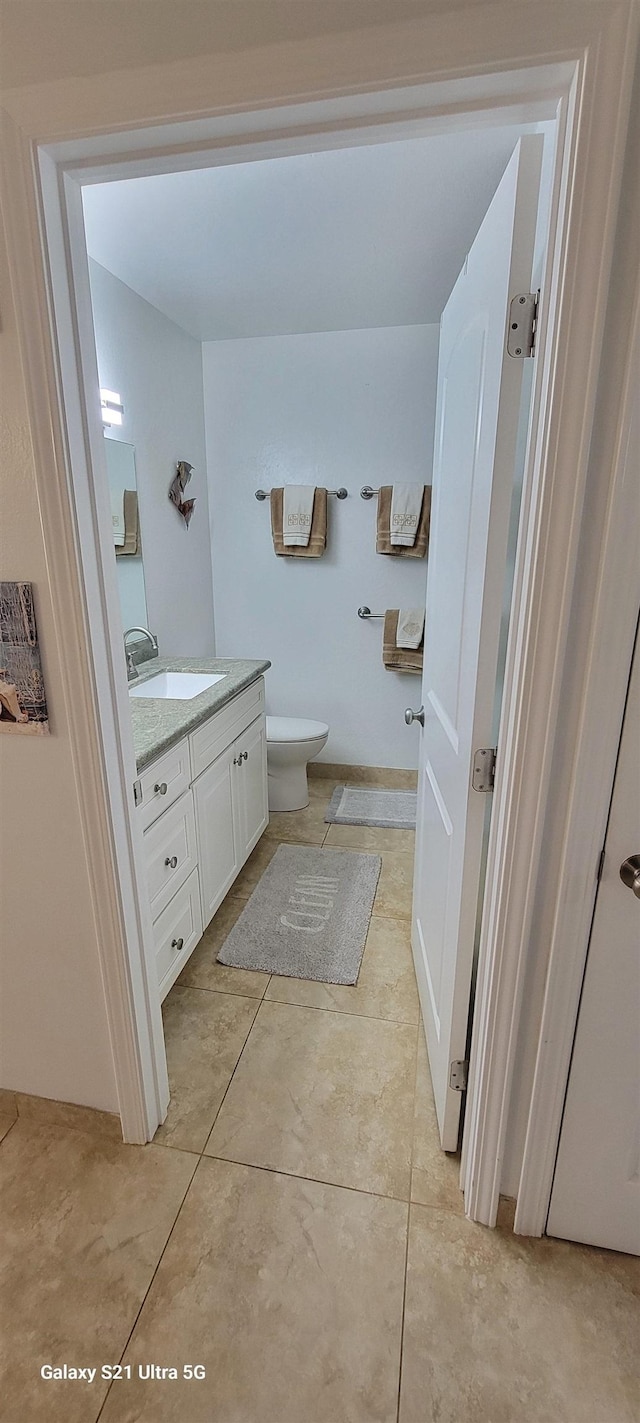 bathroom with tile patterned flooring, vanity, and toilet